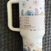 Cute cartoon Stitch and Lilo with flowers on a travel mug.
