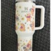 Cute Winnie the Pooh-themed insulated travel mug with adorable characters and floral accents.