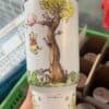 Cute illustrated design featuring Winnie the Pooh and friends in a tree.