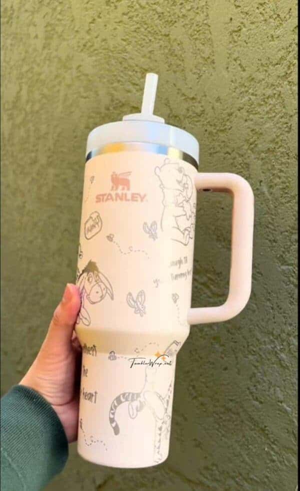 Light-colored tumbler with cute bear and animal illustrations and a travel lid.