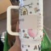 Colorful illustrated thermos with bees, flowers, and a balloon design.