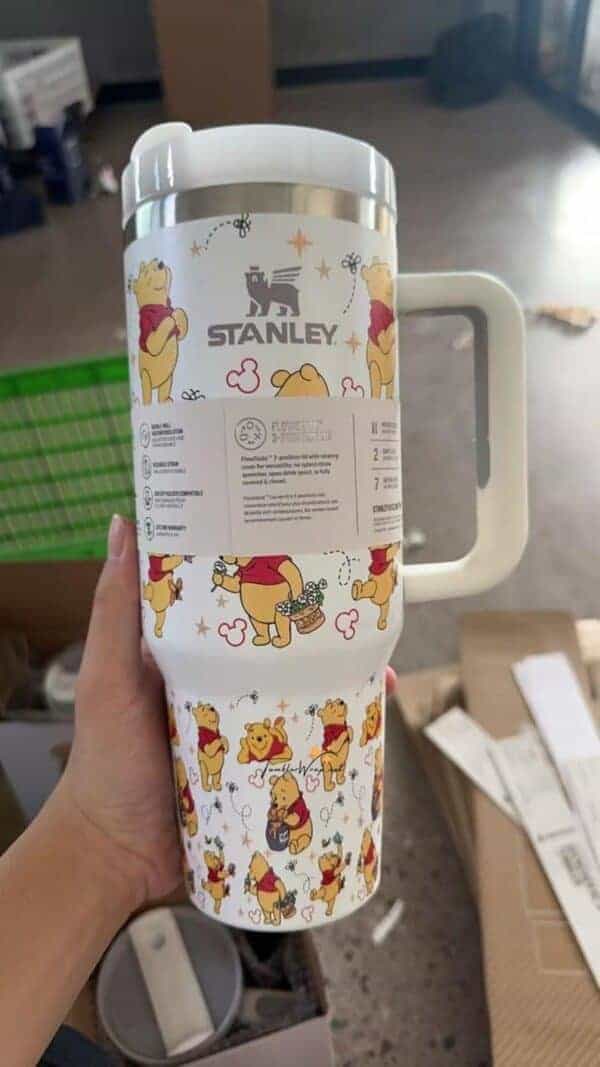 Colorful Winnie the Pooh themed coffee mug with peaceful illustrations.