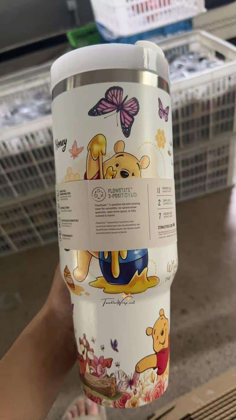 Colorful Winnie the Pooh drink cup with butterflies and floral design.