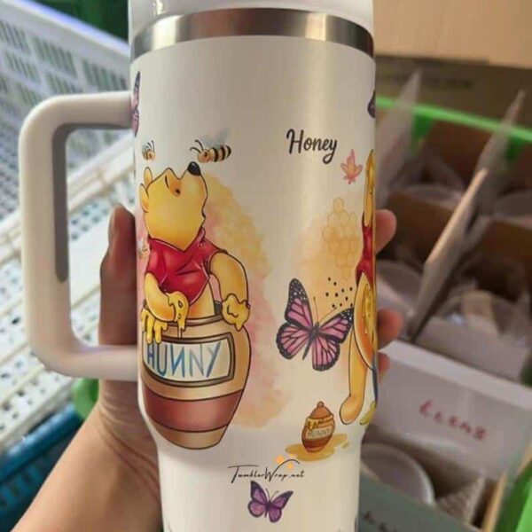 Colorful Winnie the Pooh themed honey mug featuring cartoon characters and bees.