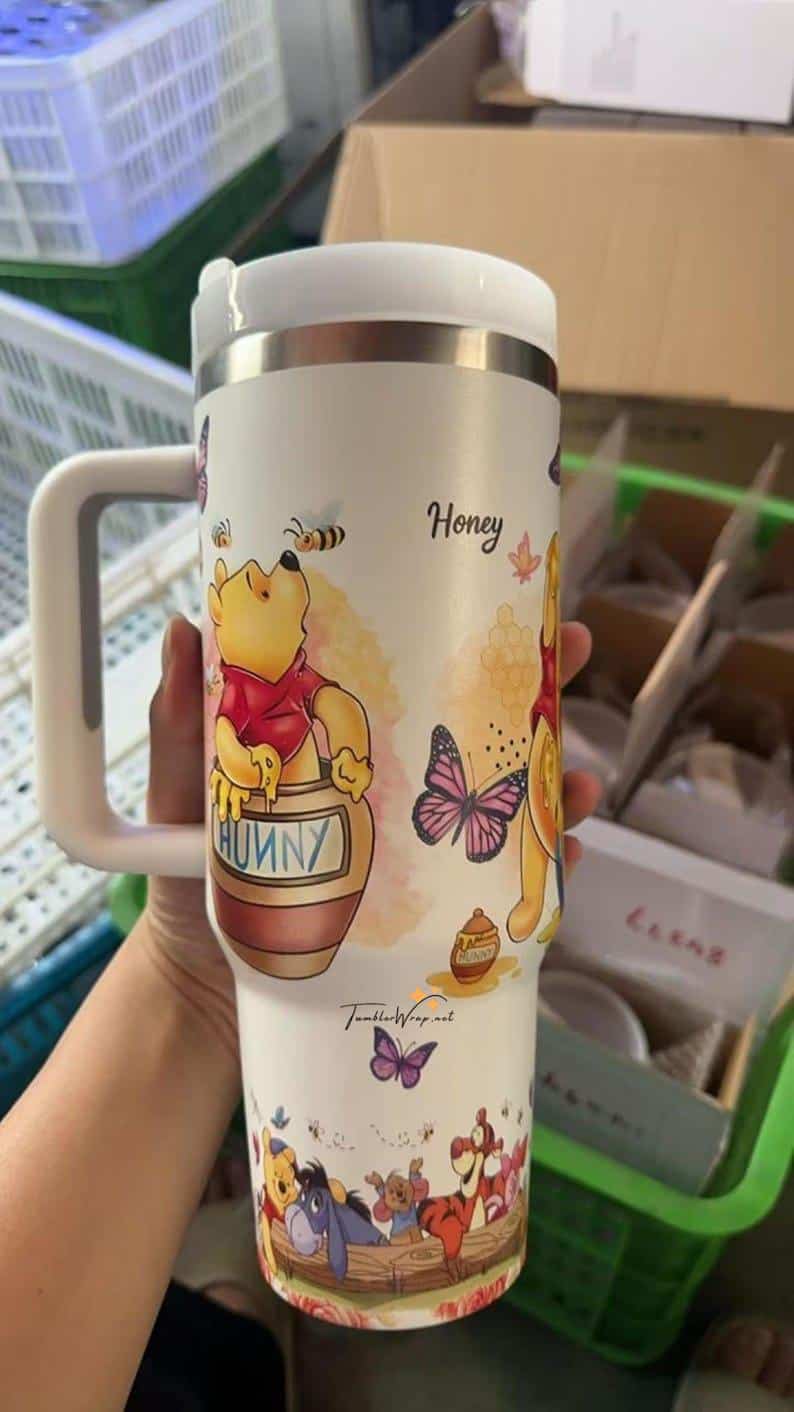 Colorful Winnie the Pooh themed honey mug featuring cartoon characters and bees.