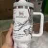 Stainless steel mug with trees, dogs, and scenic nature drawings, symbolizing peace and tranquility.