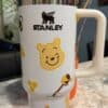Cute Winnie the Pooh thermos with honey and bee illustrations.