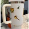 Enjoy themed coffee mug featuring honey bees and honey jar illustrations.