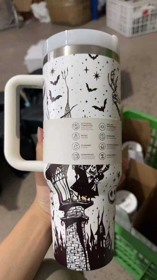 Bright ceramic mug featuring Halloween witch and haunted house designs.