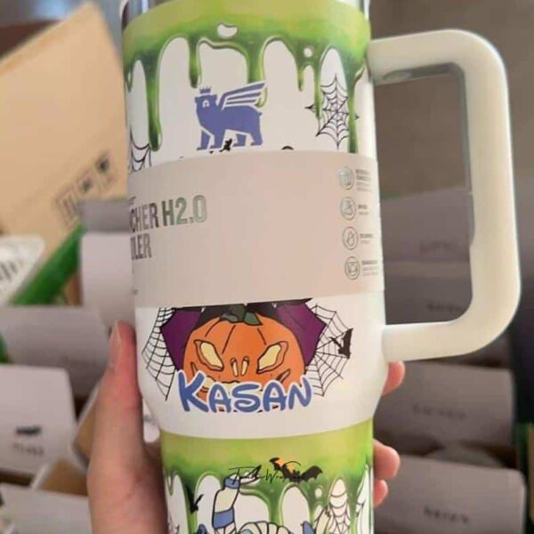 Halloween mug with pumpkin, spider webs, and monster designs for Halloween fun.