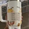 Colorful honey and bee themed travel mug with cartoon animals and flowers.