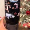Cute Winnie the Pooh and friends design on black mug with flowers, Christmas setting.