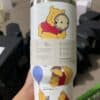 Cute Winnie the Pooh themed insulated tumbler with playful character designs.