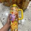 Bright honeybee-themed travel mug with cute cartoon characters and honeycomb design.