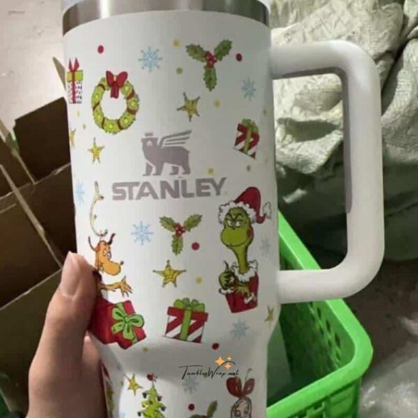 Decorative Christmas-themed mug with Santa, elf, reindeer, holly, and gift graphics.
