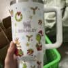 Decorative holiday travel mug with Christmas motifs and Stanley branding for festive season.