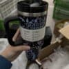 Travel mug with mountain and forest design.