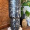 Black tumbler with white peace-themed line art.