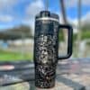Black water bottle with floral Peace SVG design.