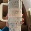 White insulated tumbler with mountain and star illustrations.