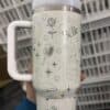 White insulated travel mug with Disney princess and magic-themed illustrations.