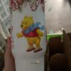 Decorative Winnie the Pooh holiday mug with Christmas theme.
