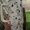 Peanuts Snoopy cup featuring illustrations of Snoopy and friends in playful poses.